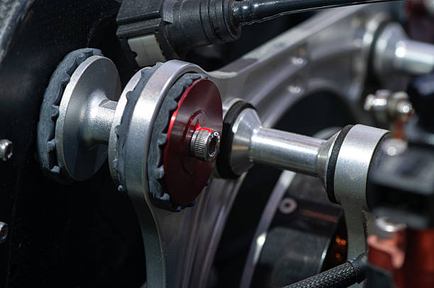 Close-up of shiny metal mechanical components and a red cap, showing intricate engineering details