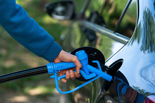 istock Man holds blue hydrogen fueling nozzle. Refueling car with hydrogen fuel 2236527681