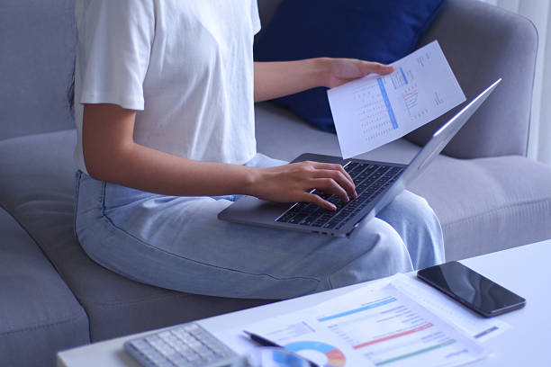 istock Closeup young women remote work from home analyzing data, using calculator and laptop. 2236529605