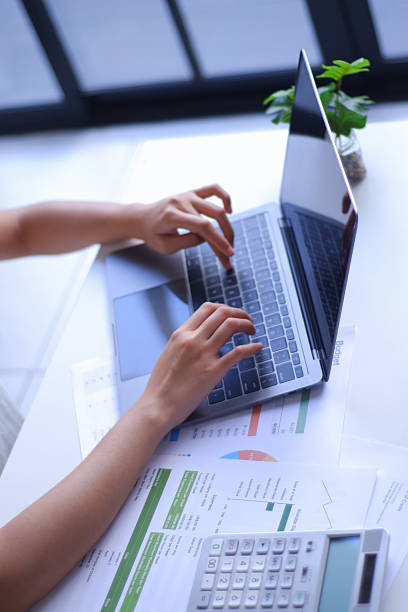 istock Closeup young women remote work from home analyzing data, using calculator and laptop. 2236529612