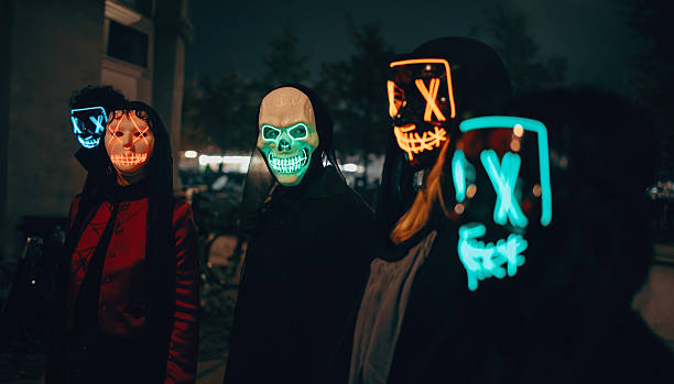 Group in neon masks gathering outdoors during nighttime