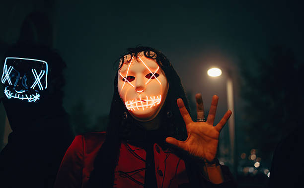 istock Masked individuals illuminated in neon light during a night city scene 2236531770