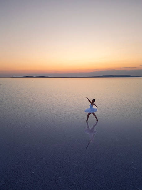 istock Ballerina performing graceful dance on still water at sunset 2236532818