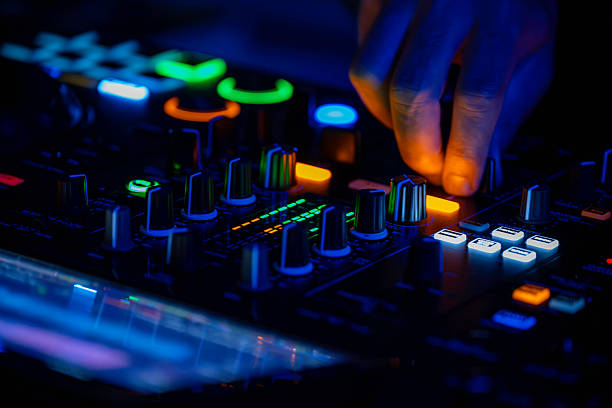 istock DJ hands mixing on console at night with colorful club lights. 2236537175