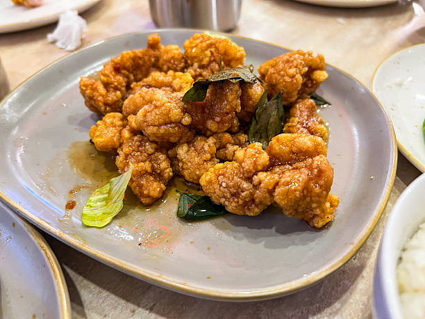 istock Crispy Fried Chicken Pieces With Basil Garnish On Plate For Shared Family Meal 2236538211