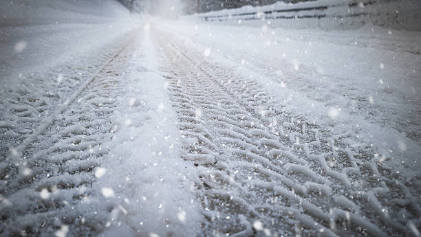 istock Winter Road with Tire Tracks in Snowfall 2236540970
