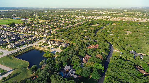 istock Upscale master planned community urban sprawl in Lantana, Texas, new construction homes surround a pond, large mansion-style homes nested in lush green trees forest. Highlights zoning diversity 2236542758
