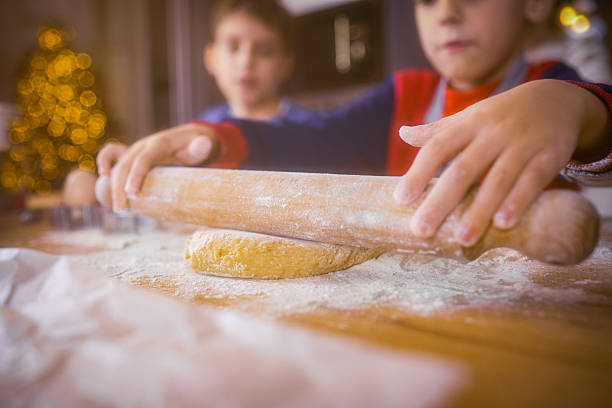 Cute family enjoying delicious biscuits just baked leaning on counter while talking and smiling very happy