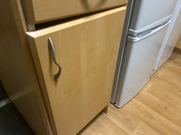 istock Wooden Kitchen Cabinet Next to Silver Fridge in Modern Home Kitchen Setting 2236547879