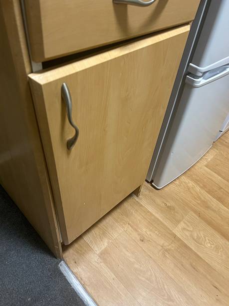 istock Wooden Kitchen Cabinet Next to Silver Fridge in Modern Home Kitchen Setting 2236547887