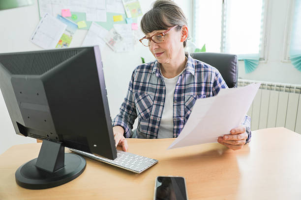 istock Woman Reviewing Financial Documents At Desk With Computer 2236549070
