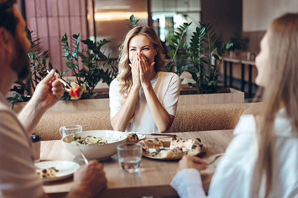 istock Friends enjoying lunch and laughing at a restaurant 2236551733