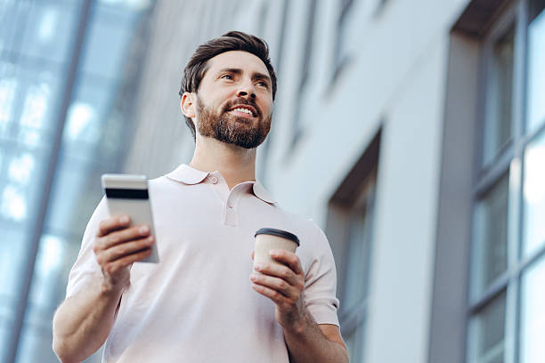 istock Man drinking coffee and using smartphone in city 2236552764