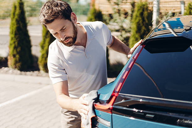 istock Man washing car outdoors cleaning vehicle 2236553207