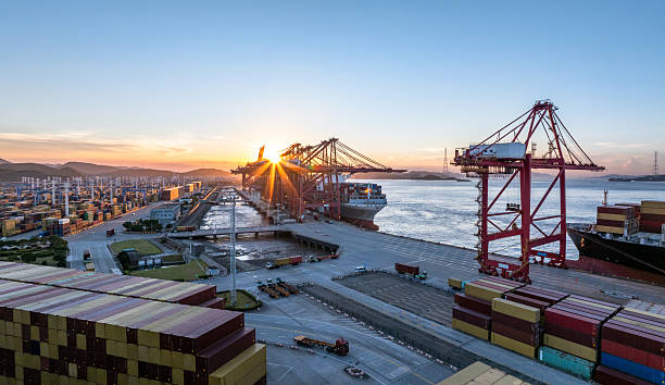 Aerial view of a port at sunset with cranes, ships