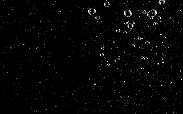 istock Clear water bubbles rising against a dark black background, symbolizing freshness, purity, air, and underwater concept. Perfect for design, abstract texture, advertising, or creative projects. 2236558189