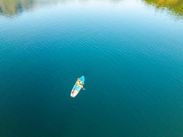 istock Woman Paddleboarding Alone on Calm Lake 2236560884