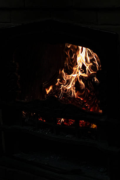 istock Flame of fire in a home fireplace on a black background 2236561027