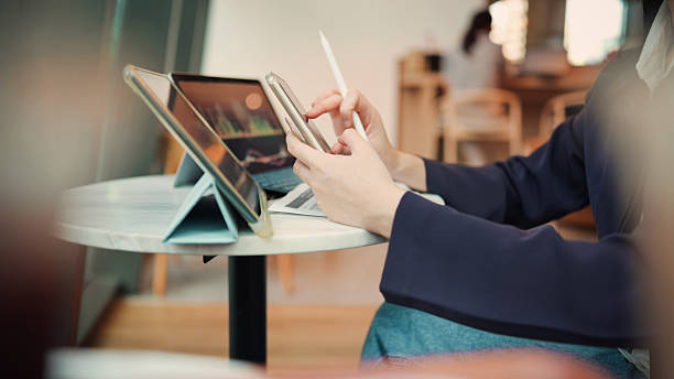 istock young asian woman interacting  using pen tablet and smartphone in smart tech setup, symbolizing creativity, artificial intelligence, and digital work engaging with ai-assisted creative apps 2236564712