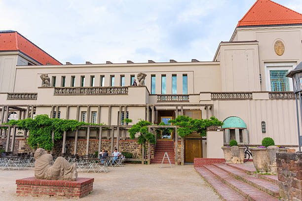 Darmstadt, Germany - June 5, 2025: Elegant architectural details of the Mathildenhoehe building in Darmstadt with surrounding sculpture and terrace seating, capturing a serene atmosphere.