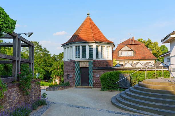Darmstadt, Germany - June 18, 2025: Scenic view of the Sculptors' Studios in Darmstadt, featuring unique architectural elements, vibrant greenery, and a serene atmosphere under clear blue skies.