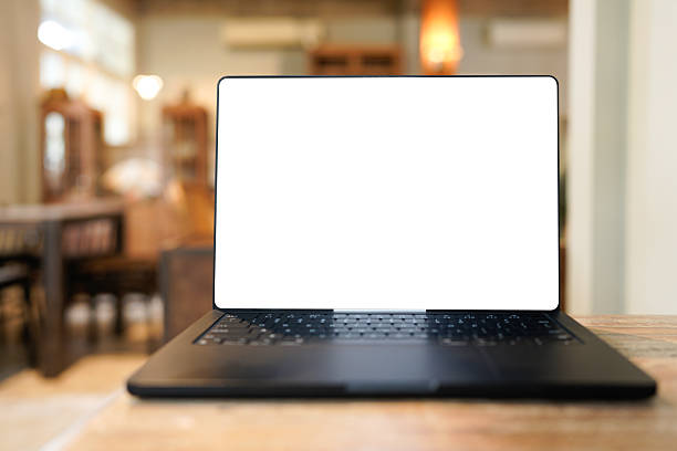 istock Modern laptop computer with blank screen sits on wooden table in a trendy cafe setting, showcasing a blurred background of warm lighting 2236570301