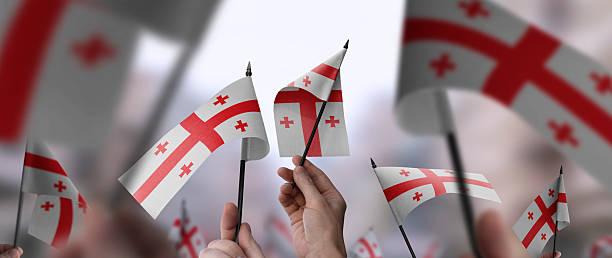 istock Georgia flags in their hands on a blurred urban background 2236572140