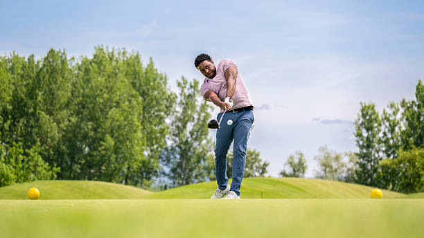 Golfer on the professional golf course. Golfer with golf club hitting the ball for the perfect shot. Sport and healthy lifestyle concept.