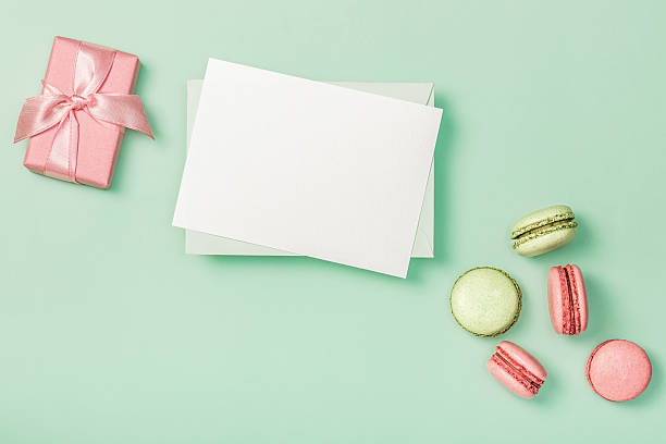 istock Flat lay composition with blank empty, pink gift box and colorful macaroons on light green background. Greeting card. Invitation. 2236572604