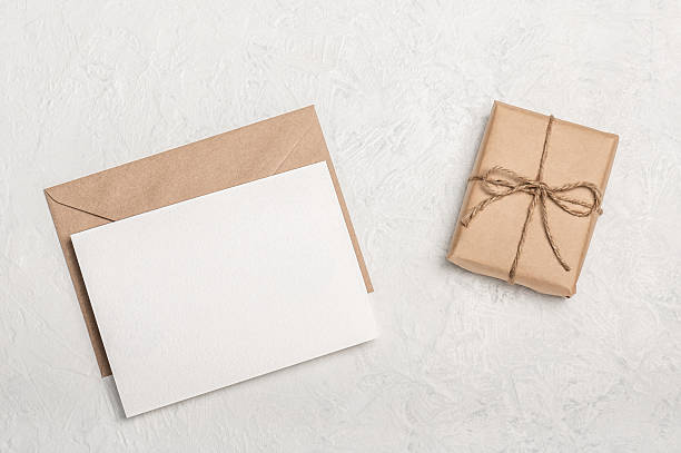 istock Invitation or greeting card mockup, craft envelope with craft gift box on light background. Blank postcard. 2236572760