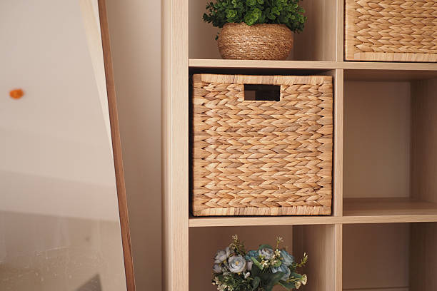 istock Natural wicker storage basket on wooden shelf with plants 2236572923