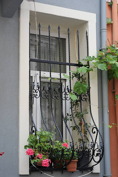 istock Decorative window with iron bars and vibrant flowers in urban setting 2236575760