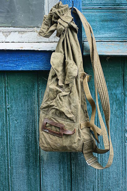 istock One old army green backpack hangs on the wooden wall 2236580006