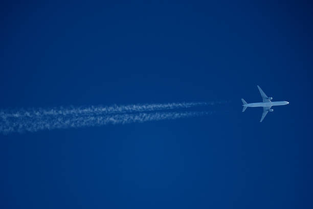 istock Airplane in the blue sky with contrail. 2236583145