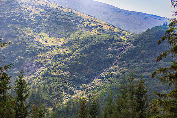 istock green mountain slopes and mountain river, waterfall 2236584301