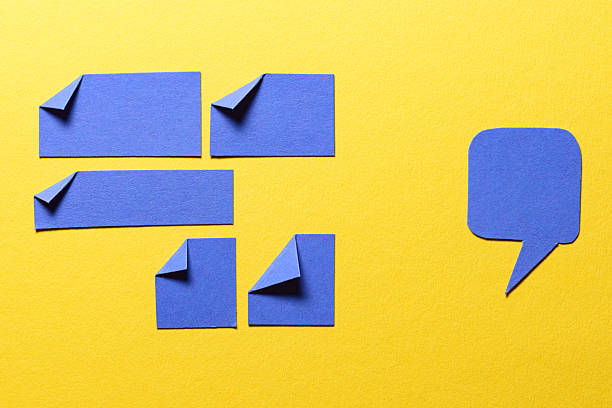 istock Blue speech bubble and paper memo notes with folded dog-ear earmark and copy space for text on yellow background, communication dialog concept top view flat lay 2236587034