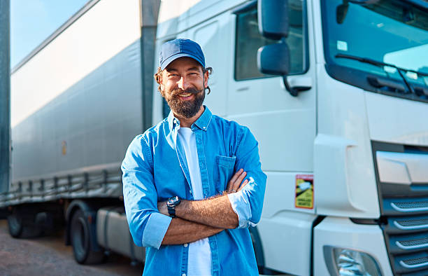 istock Smiling truck driver standing confidently by semi-trailer 2236588196