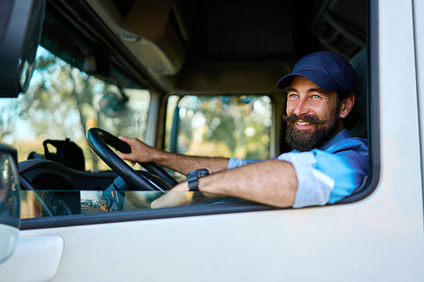 istock Happy truck driver steering vehicle on sunny day 2236588231