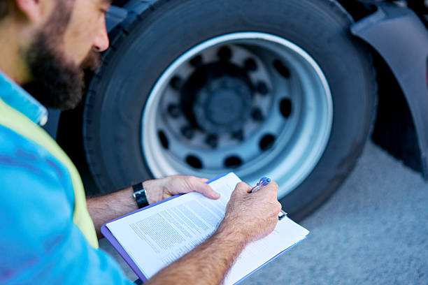 istock Truck driver checking truck tire before journey 2236588396