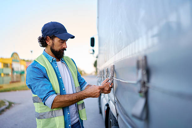 istock Truck driver securing cargo on semi-truck trailer 2236588403