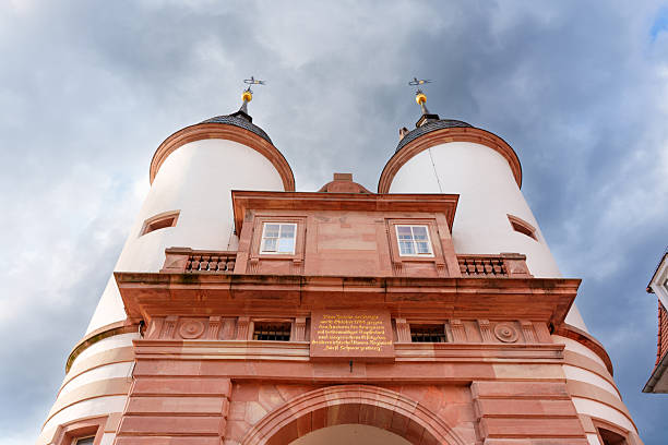 Heidelberg, Germany - June 8, 2025: Close-up view of the historic gatehouse in Heidelberg, Germany, featuring twin towers and ornate architectural details under a moody sky.
