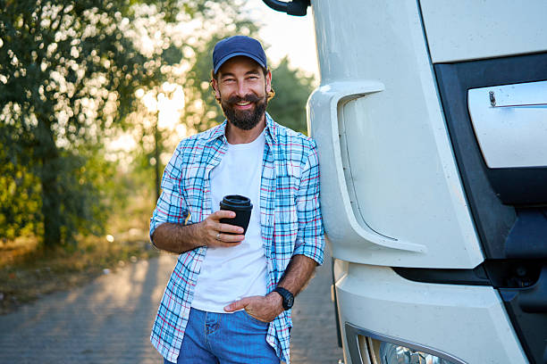 istock Male truck driver smiling and holding coffee cup 2236588430