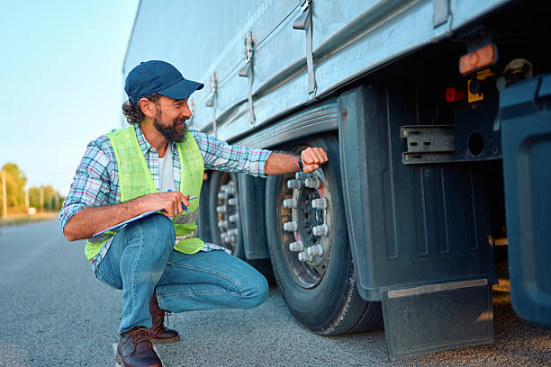 istock Truck driver checking heavy vehicle tire pressure before trip 2236588468