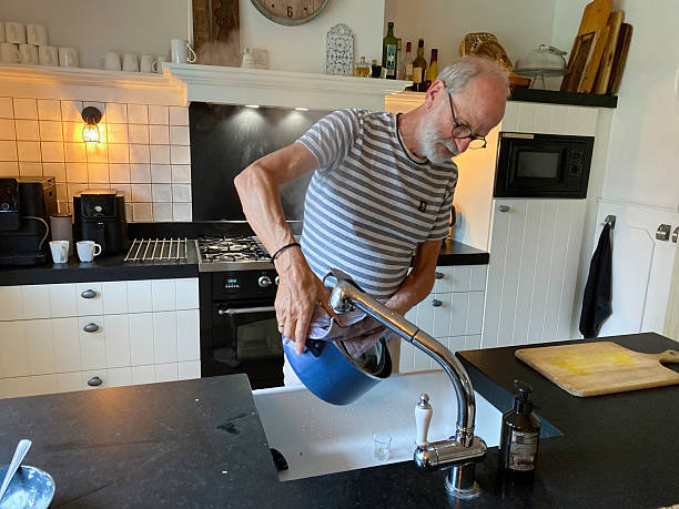 istock Senior Man draining Endive Stew on a Sunday afternoon. 2236591114
