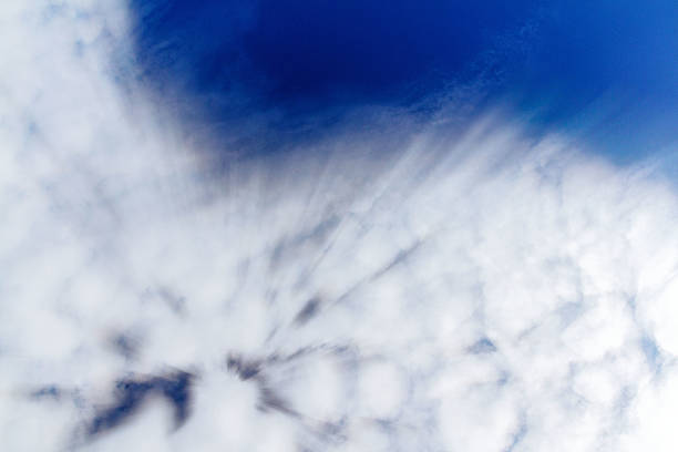 A blurred abstract view of a blue sky with soft white clouds. A natural atmospheric background, dreamy texture, and peaceful sky concept for design and inspiration.