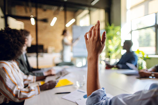istock Team Member Raising Hand During Collaborative Business Meeting in Modern Office 2236594781