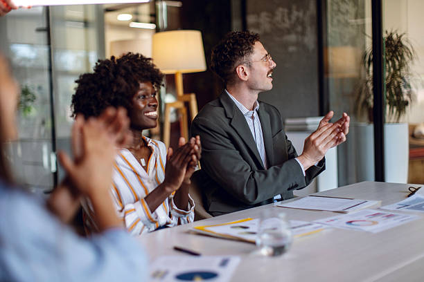 istock Team Applauding During Business Meeting in Modern Office Environment 2236594782