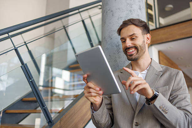 istock Happy businessman smiling and using digital tablet in office 2236596514