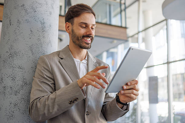 istock Businessman smiling and using digital tablet in modern office 2236596531