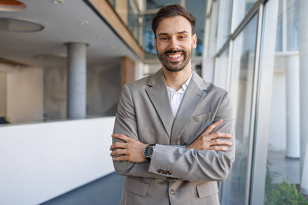 istock Happy professional man smiling with arms crossed in modern office 2236596549